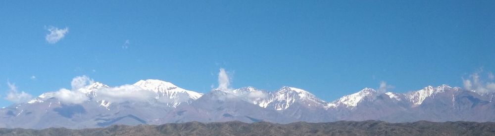 Low angle view of snowcapped mountains against sky