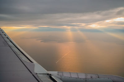 Airplane flying in sky during sunset