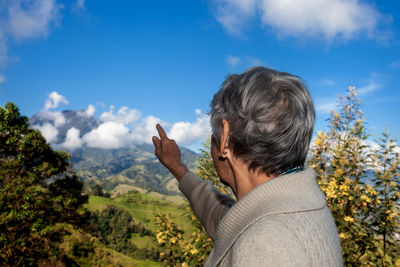 Senior woman tourist looking at the  landscapes of the central ranges in colombia. travel concept