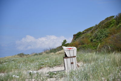 Lifeguard hut on field against sky