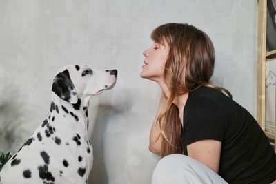 Side view of woman with dog at home