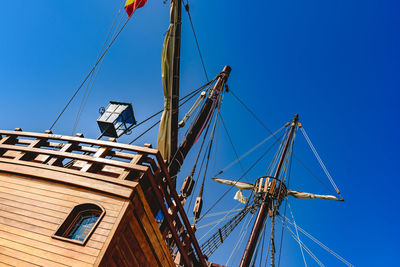 Low angle view of sailboat against clear blue sky