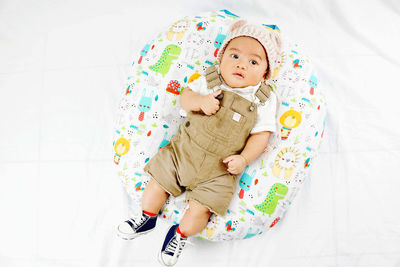 High angle view of baby lying on bed at home