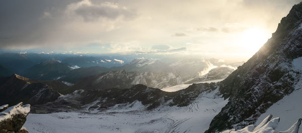 Sun setting behind mountain in high alpine environment with snow and glaciers, austrian alps, europe