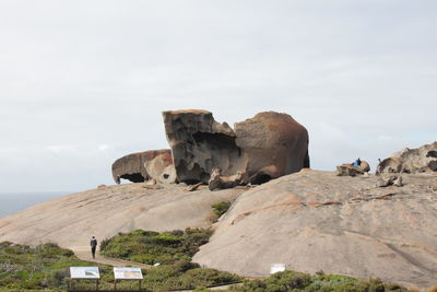 Rock formation by sea against sky