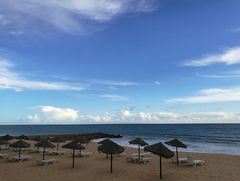 Chairs on beach against sky