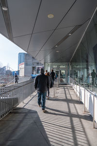 Rear view of people walking on zebra crossing