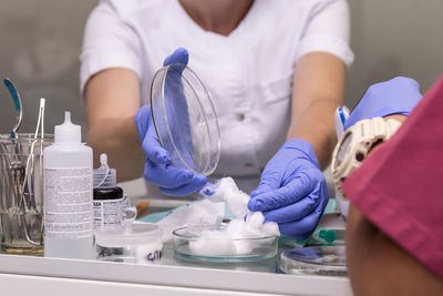 Midsection of nurse holding cotton in operating room