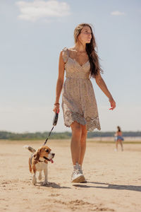 Portrait of young woman with dogs on beach