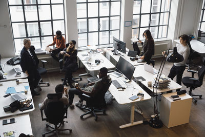 Business people discussing over product during meeting in creative office