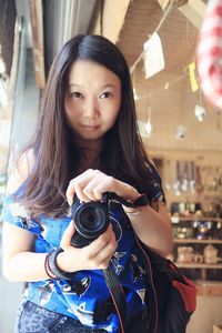 Portrait of young woman photographing