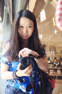 Young woman photographing while dslr camera
