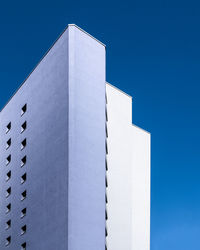 Low angle view of modern building against clear blue sky