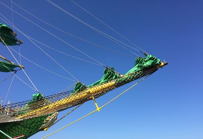 Low angle view of power lines against clear blue sky