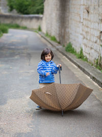 Little handsome baby boy playing with umbrella outdoor