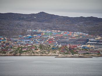 Aerial view of city street against cloudy sky