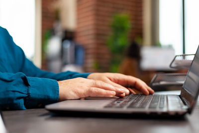 Midsection of man using laptop on table