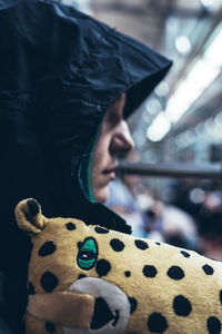 Close-up of thoughtful woman wearing hood sitting in vehicle