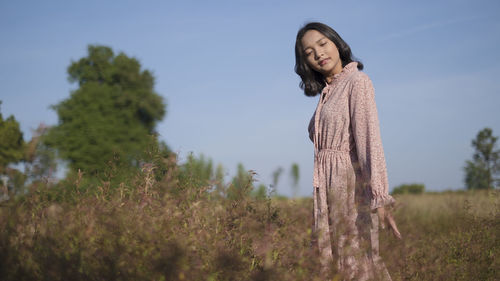 Woman standing on field against sky