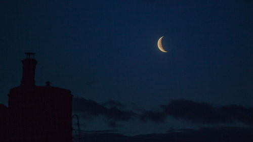 Low angle view of silhouette moon against sky at night