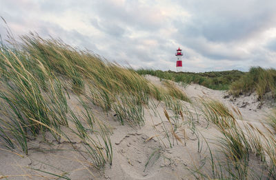 Lighthouse on land against sky