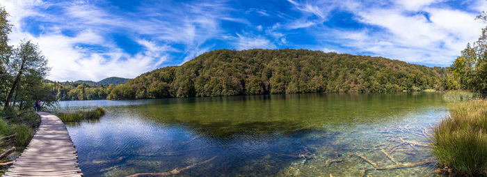 Scenic view of lake by trees against blue sky