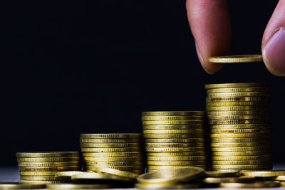 Close-up of a hand holding stack of black background