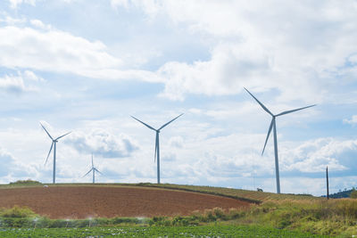 Windmill on field against sky