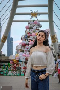 Portrait of young woman standing against built structure