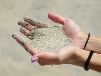 Close-up of human hand holding sand