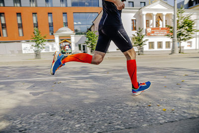 Rear view of woman jumping on street