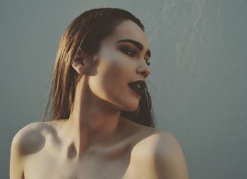 Close-up of young woman against gray background