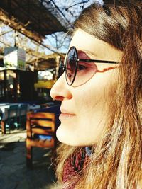 Close-up profile view of woman with brown hair wearing sunglasses