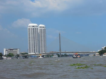 Sea by city against sky