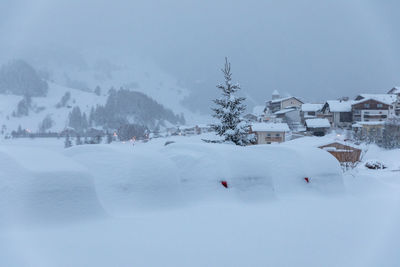 Houses on snow covered landscape against sky