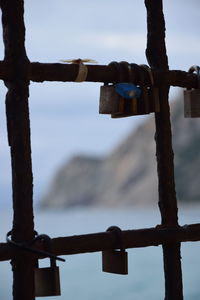 Close-up of padlocks on railing against sky