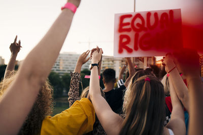 Rear view of friends protesting for equal rights in city