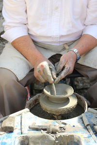 Midsection of man working in mud