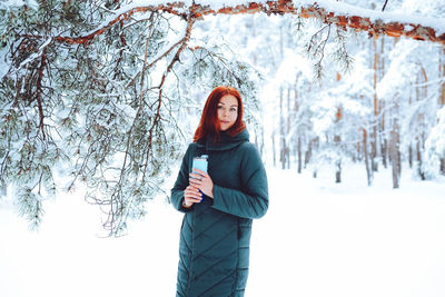 Young beautiful woman in winter forest with fir trees person