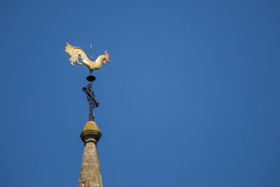 Low angle view of statue against clear blue sky