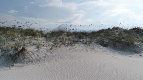 Scenic view of sand dune against sky