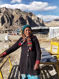 Senior woman standing against mountain