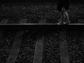 Low section of person standing on railroad track