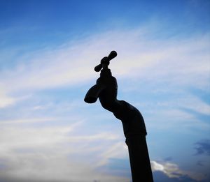 Low angle view of silhouette faucet against sky