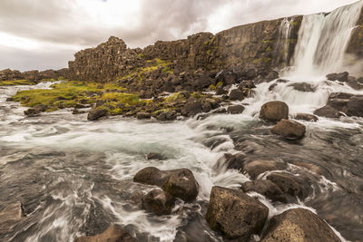 Scenic view of waterfall against sky