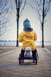 Rear view of boy sitting on snow