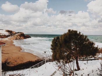 High angle view of calm beach against clouds