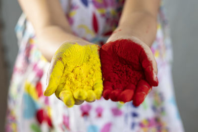 Selective focus on colorful palms of a pretty indian girl child during holi