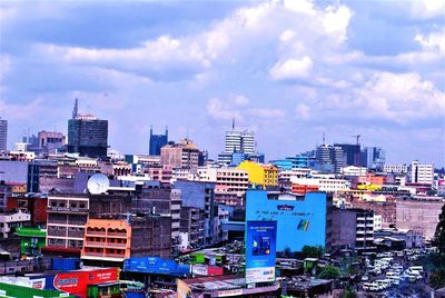 View of cityscape against cloudy sky