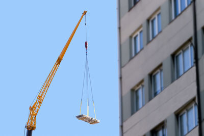 Industrial crane telescopic vehicle working in construction site on city street  with blue sky